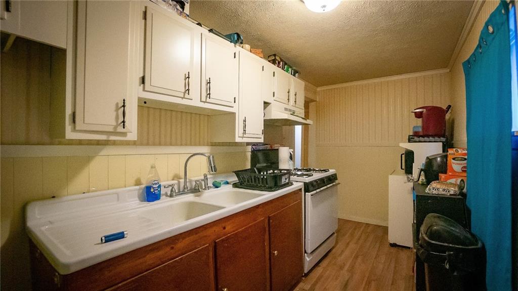 135 Hickory Street Butler, PA 16001 - Photo 6 of 25 a kitchen with a sink a stove and cabinets