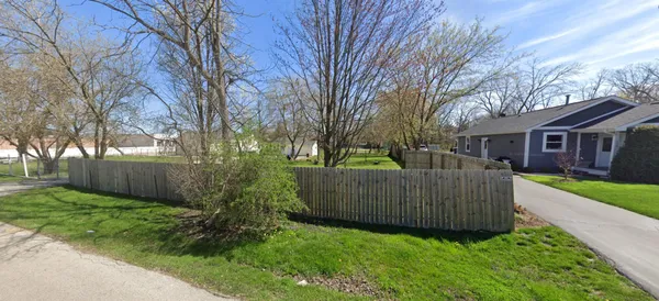 a view of a house with backyard and a tree