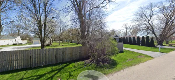 a view of a backyard with wooden fence