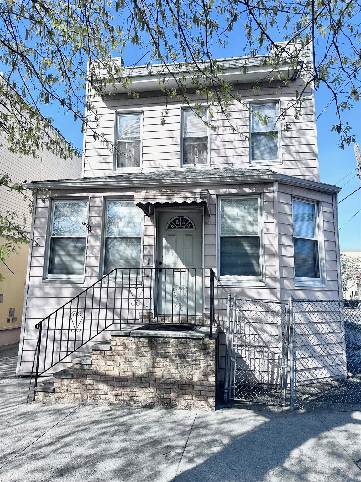 71-50 73rd Place Queens, NY 11385 - Photo 1 of 1 View of front facade with a gate and fence