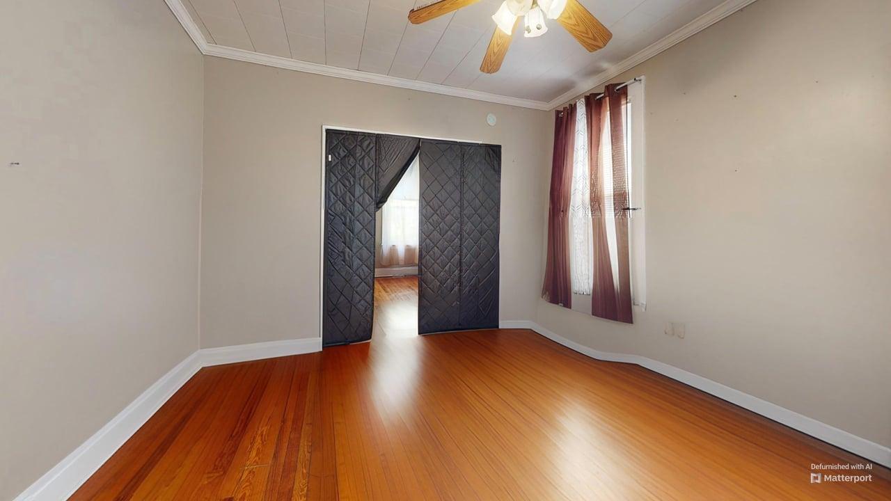 71-50 73rd Place Queens, NY 11385 - Photo 17 of 24 Empty room with baseboards, ornamental molding, a ceiling fan, and wood finished floors