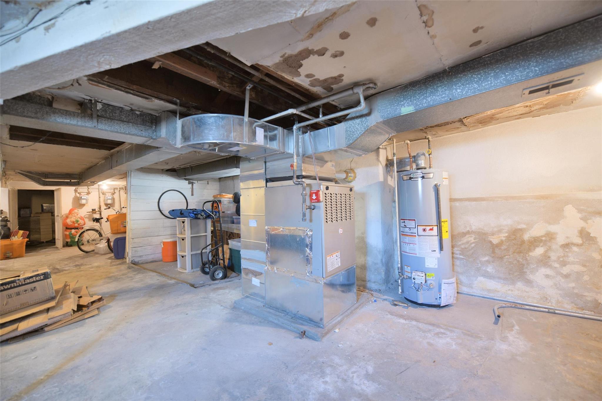 71-50 73rd Place Queens, NY 11385 - Photo 22 of 24 Unfinished basement featuring heating unit and gas water heater