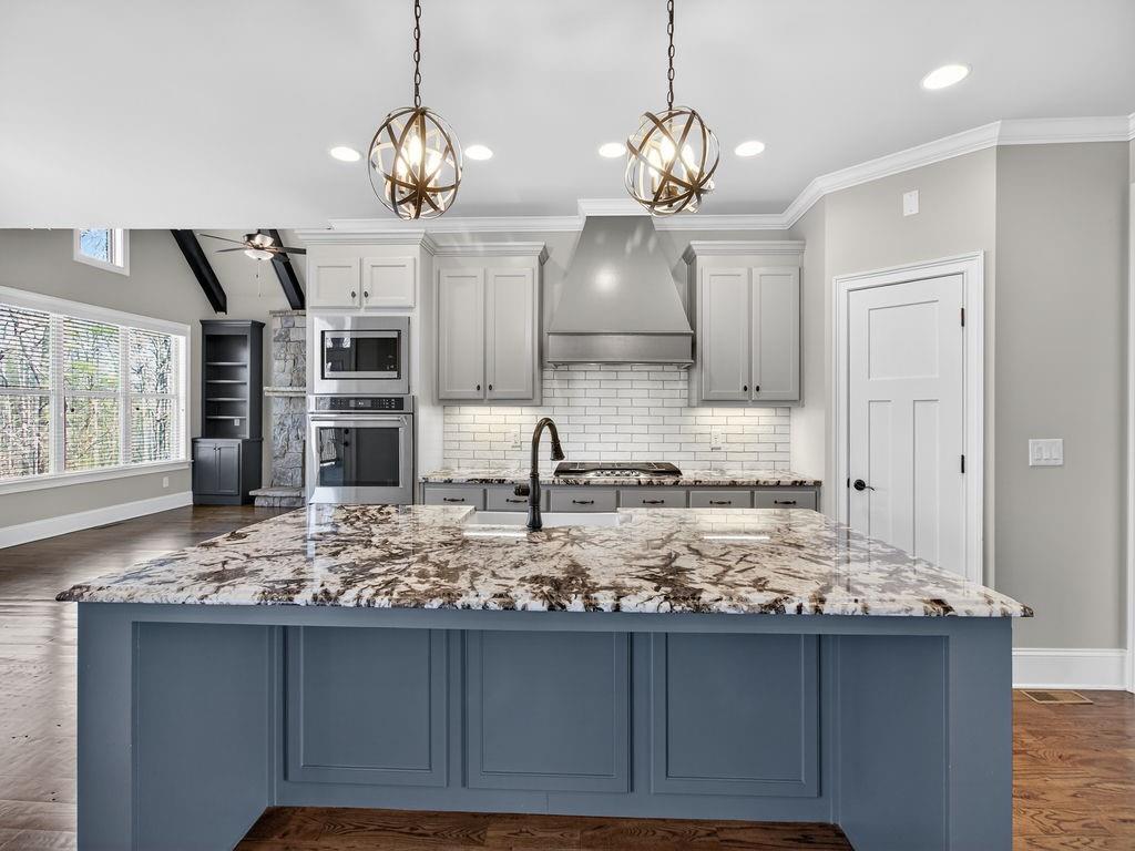 436 Thunder Road Buford, GA 30518 - Photo 12 of 62 a kitchen with kitchen island granite countertop a stove and a wooden floors