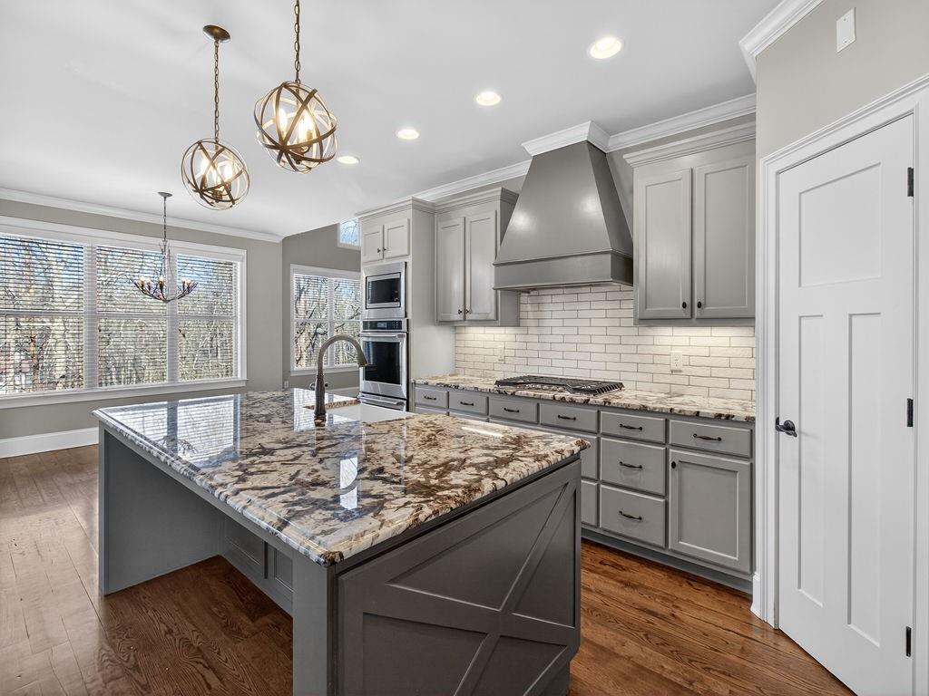 436 Thunder Road Buford, GA 30518 - Photo 14 of 62 a kitchen with kitchen island granite countertop a stove and a wooden floors