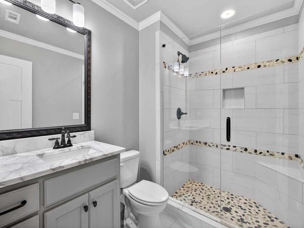 436 Thunder Road Buford, GA 30518 - Photo 19 of 62 a bathroom with a granite countertop sink a toilet a mirror and shower