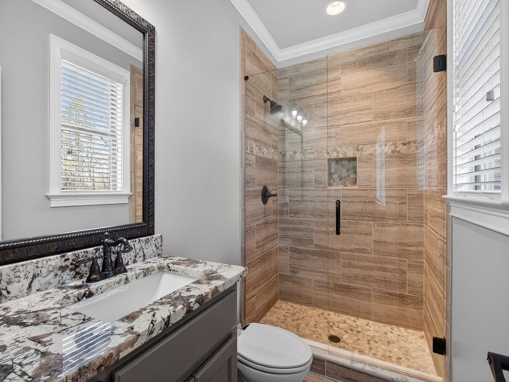 436 Thunder Road Buford, GA 30518 - Photo 30 of 62 a bathroom with a granite countertop sink toilet a mirror a bathtub and shower