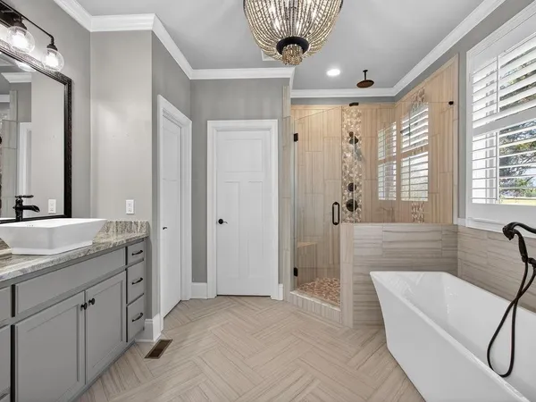 a spacious bathroom with a tub sink and mirror