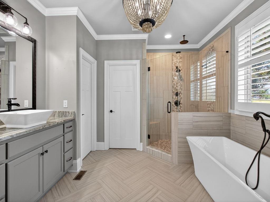 436 Thunder Road Buford, GA 30518 - Photo 36 of 62 a spacious bathroom with a granite countertop sink a mirror a bathtub and shower