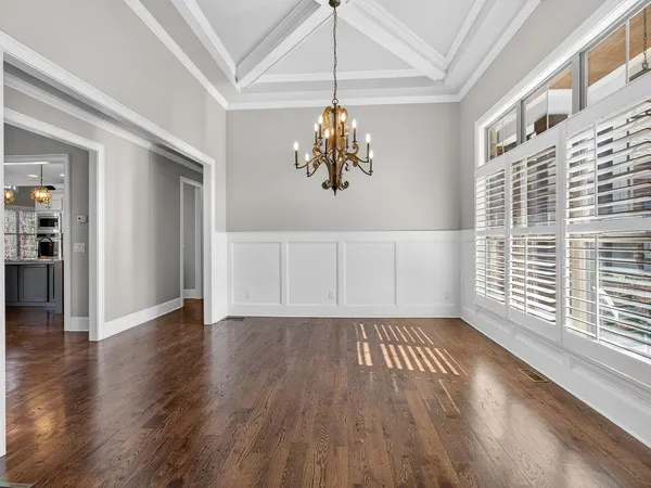 a view of an empty room with chandelier and a window