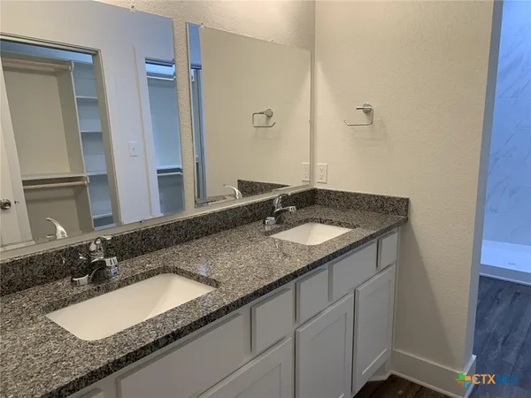 a bathroom with a granite countertop sink and a mirror