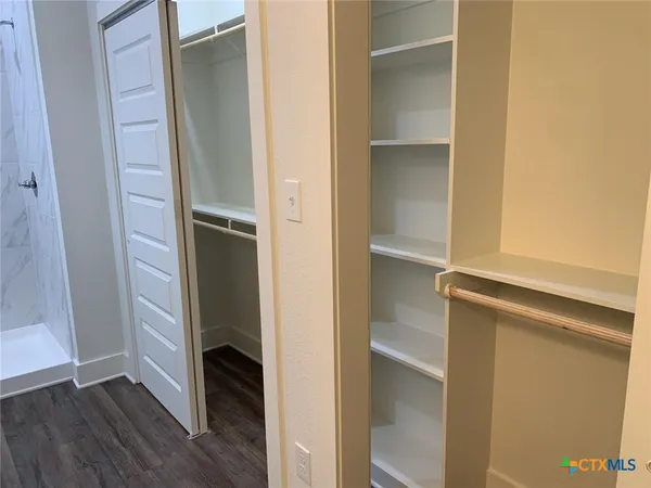a view of walk in closet with empty racks