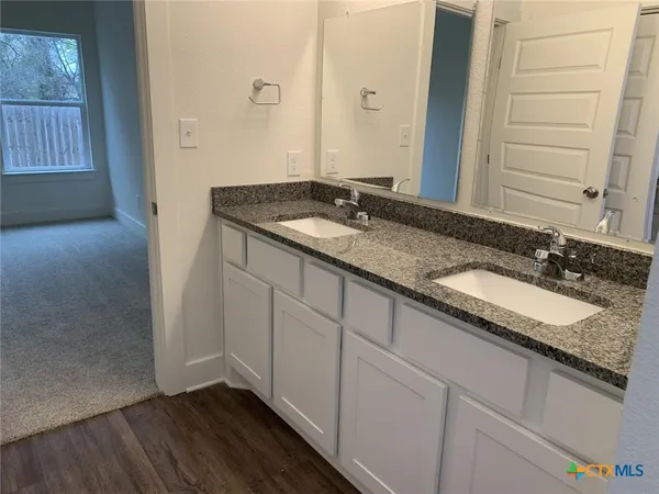 a bathroom with a granite countertop sink and a mirror