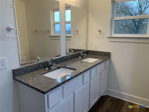 a bathroom with a granite countertop sink and a mirror