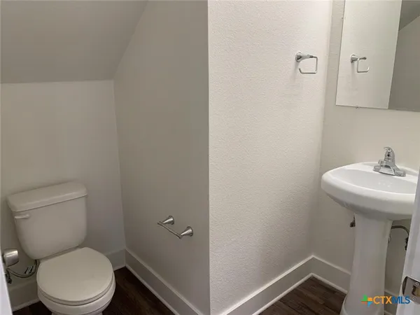 a bathroom with a sink toilet and a mirror