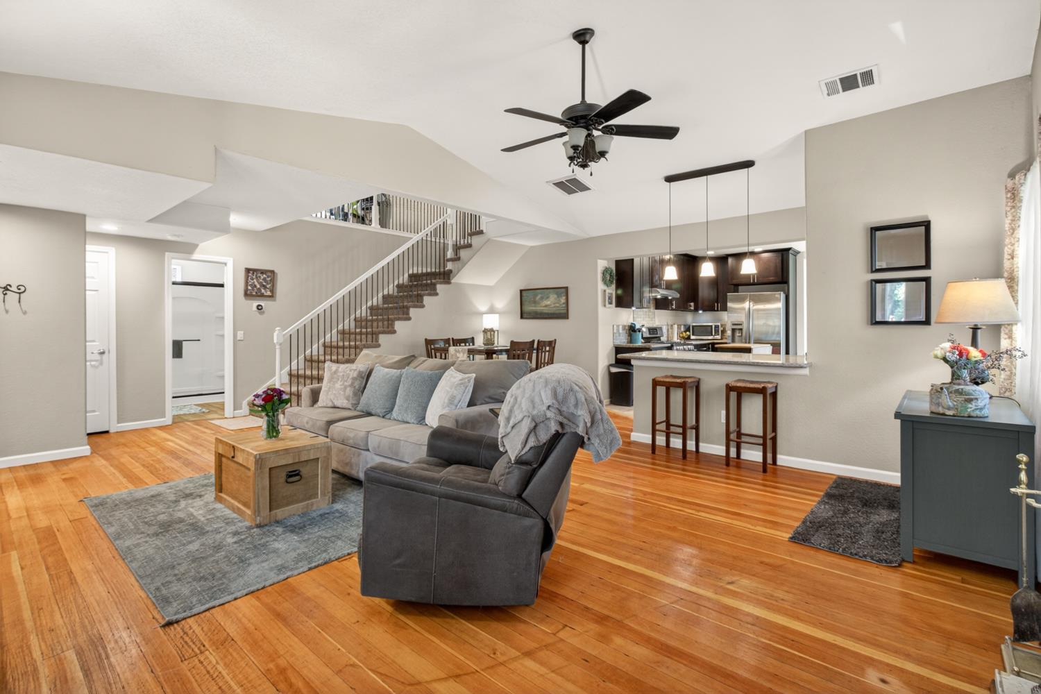 6332 Horseshoe Bar Road Loomis, CA 95650 - Photo 12 of 85 Open-concept living space featuring wood-finish flooring, a contemporary ceiling fan, and a staircase with white risers and railings