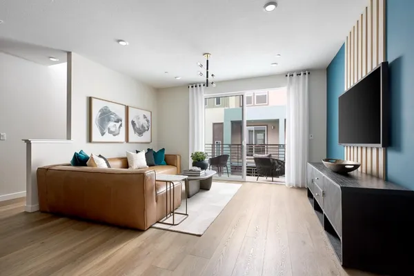 a living room with furniture a flat screen tv and a floor to ceiling window
