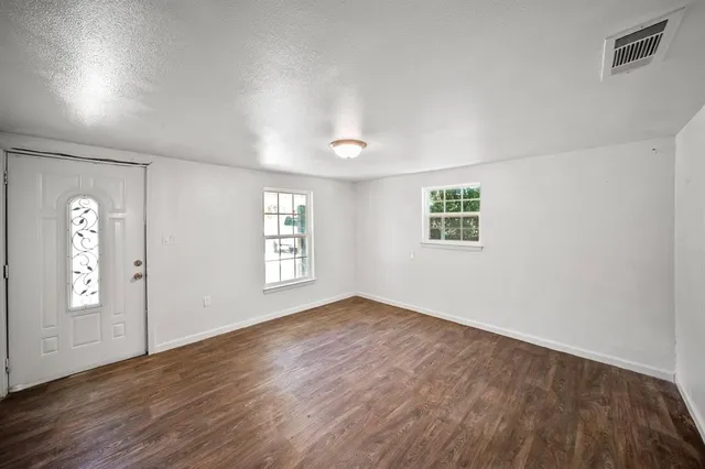 an empty room with windows and closet