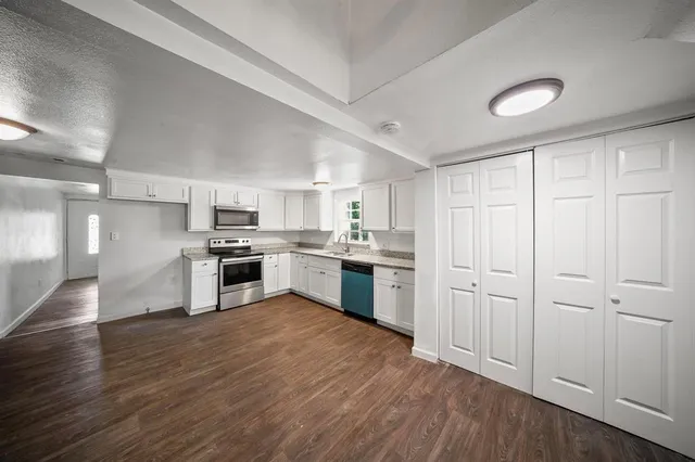 a kitchen with white cabinets and stainless steel appliances