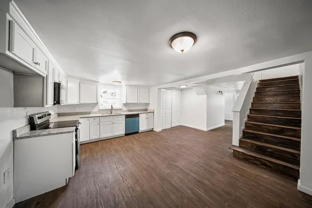 a kitchen with white cabinets and sink