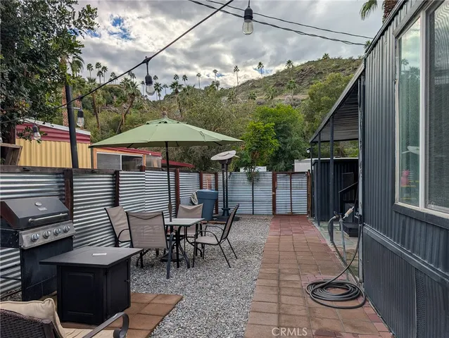 a backyard of a house with barbeque oven table and chairs