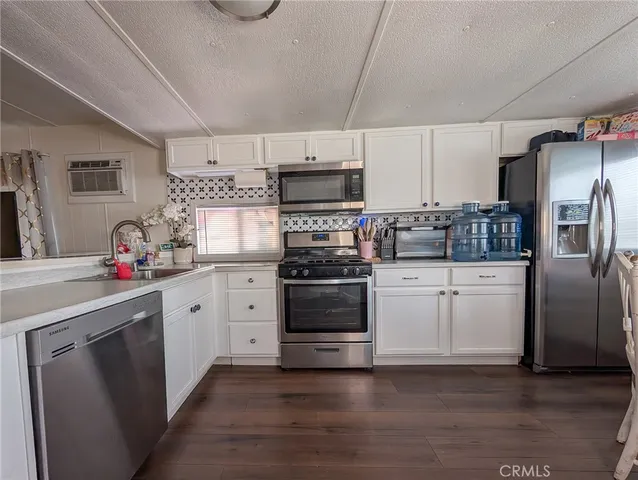 a kitchen with granite countertop a refrigerator stove and sink