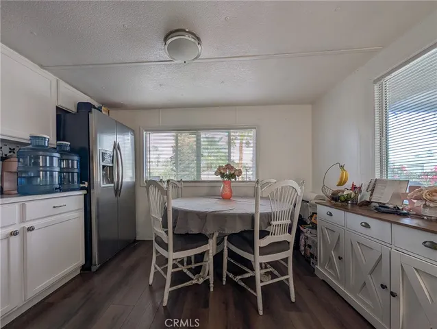 a dining room with stainless steel appliances kitchen island granite countertop furniture and wooden floor