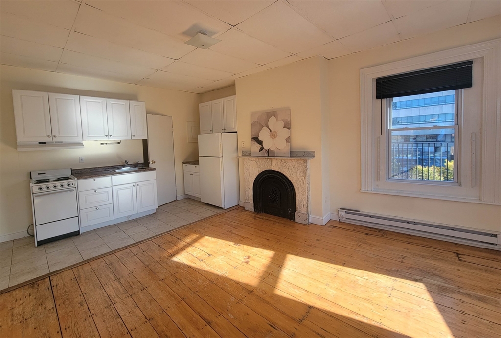a view of a kitchen with a sink dishwasher and a fireplace