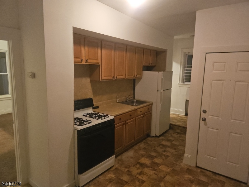 69 Passaic Street Garfield, NJ 07026 - Photo 3 of 6 a kitchen with a stove and a refrigerator