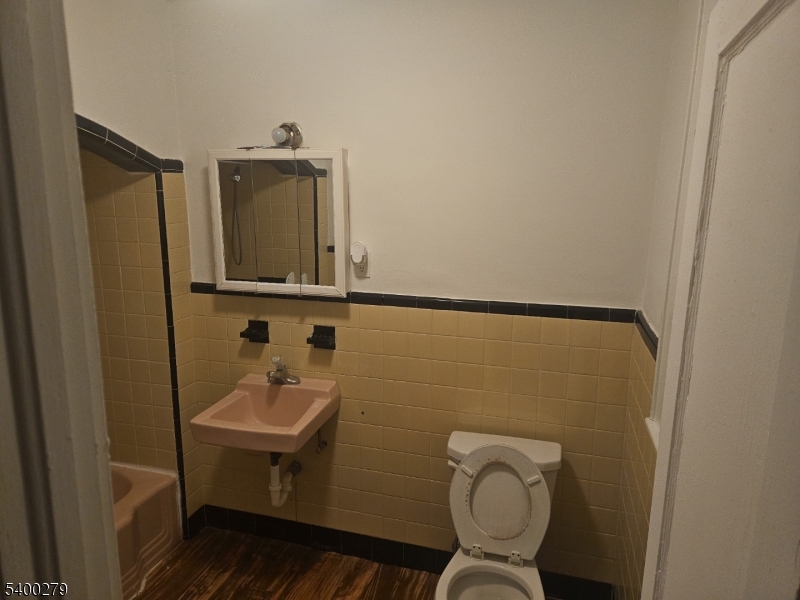 69 Passaic Street Garfield, NJ 07026 - Photo 5 of 6 a bathroom with a sink toilet and mirror