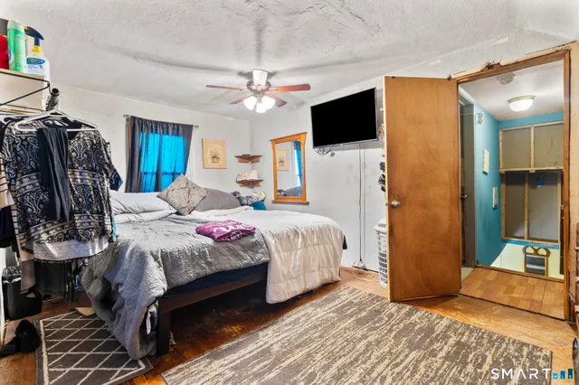 a bedroom with a bed a dresser and potted plants on the dresser