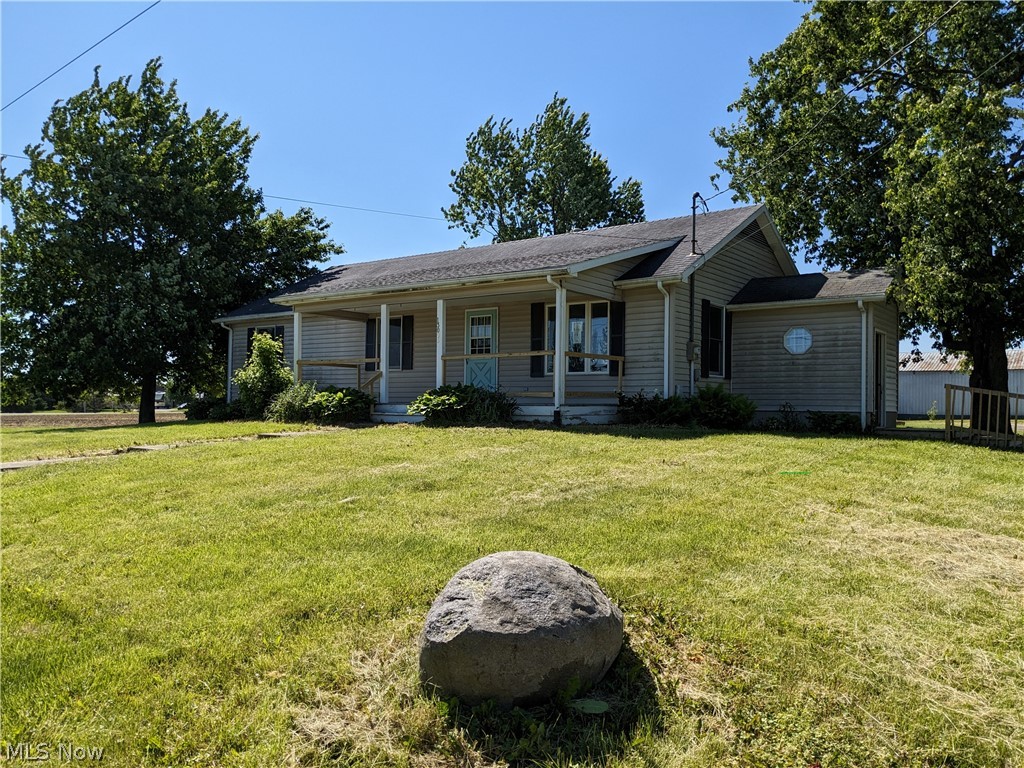 Single-story residence featuring light-colored siding, a covered front porch, and a gable roofline