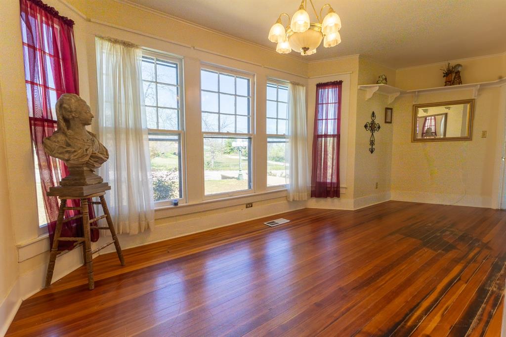 1115 Austin Street Coleman, TX 76834 - Photo 12 of 40 a view of an empty room with a window and wooden floor