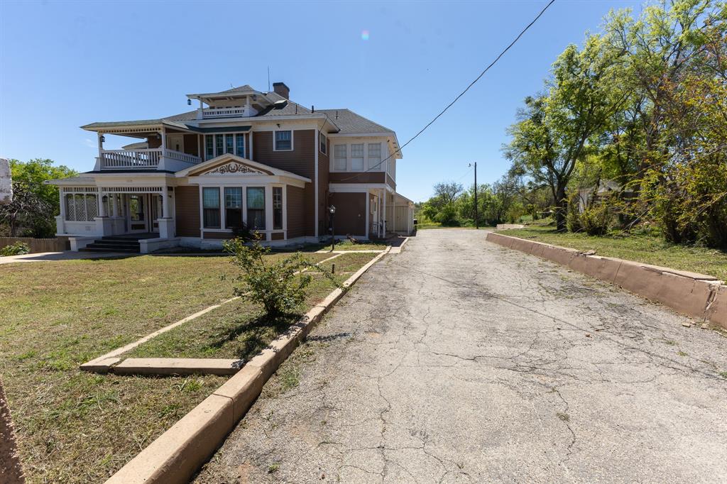 1115 Austin Street Coleman, TX 76834 - Photo 29 of 40 a view of a big house with a big yard plants and large trees