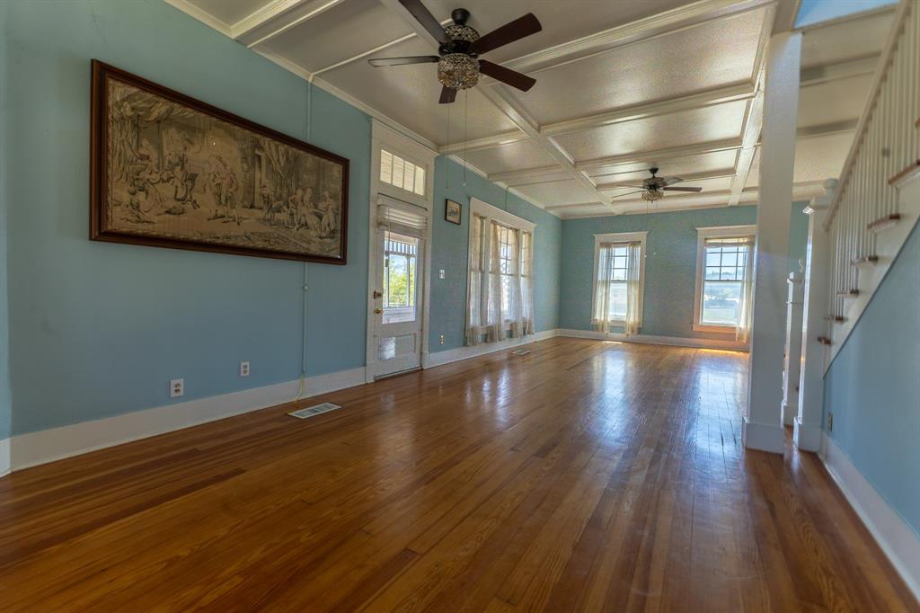 1115 Austin Street Coleman, TX 76834 - Photo 4 of 40 a view of a room with wooden floor and a ceiling fan