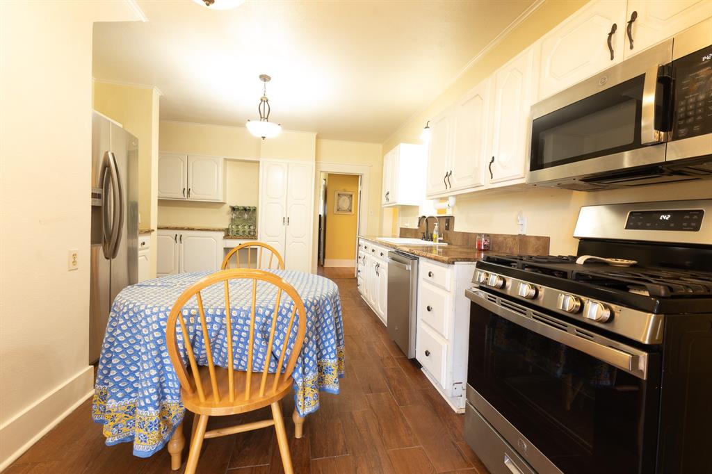 1115 Austin Street Coleman, TX 76834 - Photo 10 of 40 a kitchen with stainless steel appliances a stove a sink dishwasher and a refrigerator