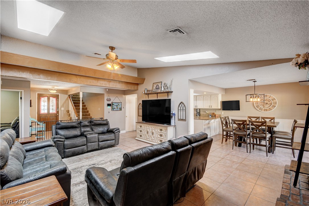 Vaulted ceilings with skylights bring abundant architectural depth to this spacious open living area.