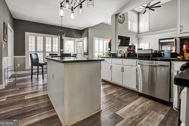 a kitchen with granite countertop a sink cabinets and wooden floor