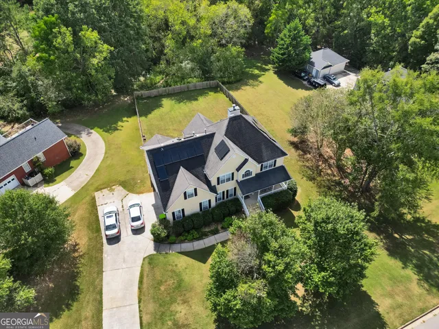 an aerial view of a house with swimming pool and lake view
