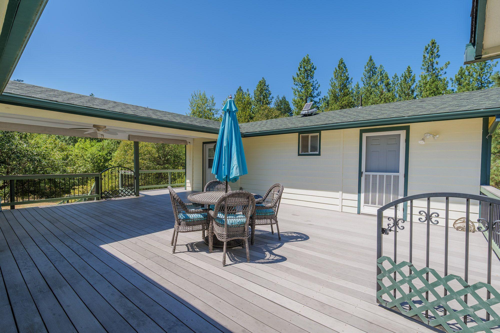 9266 Lower River Road Grants Pass, OR 97526 - Photo 25 of 39 a roof deck with table and chairs and potted plants with wooden floor
