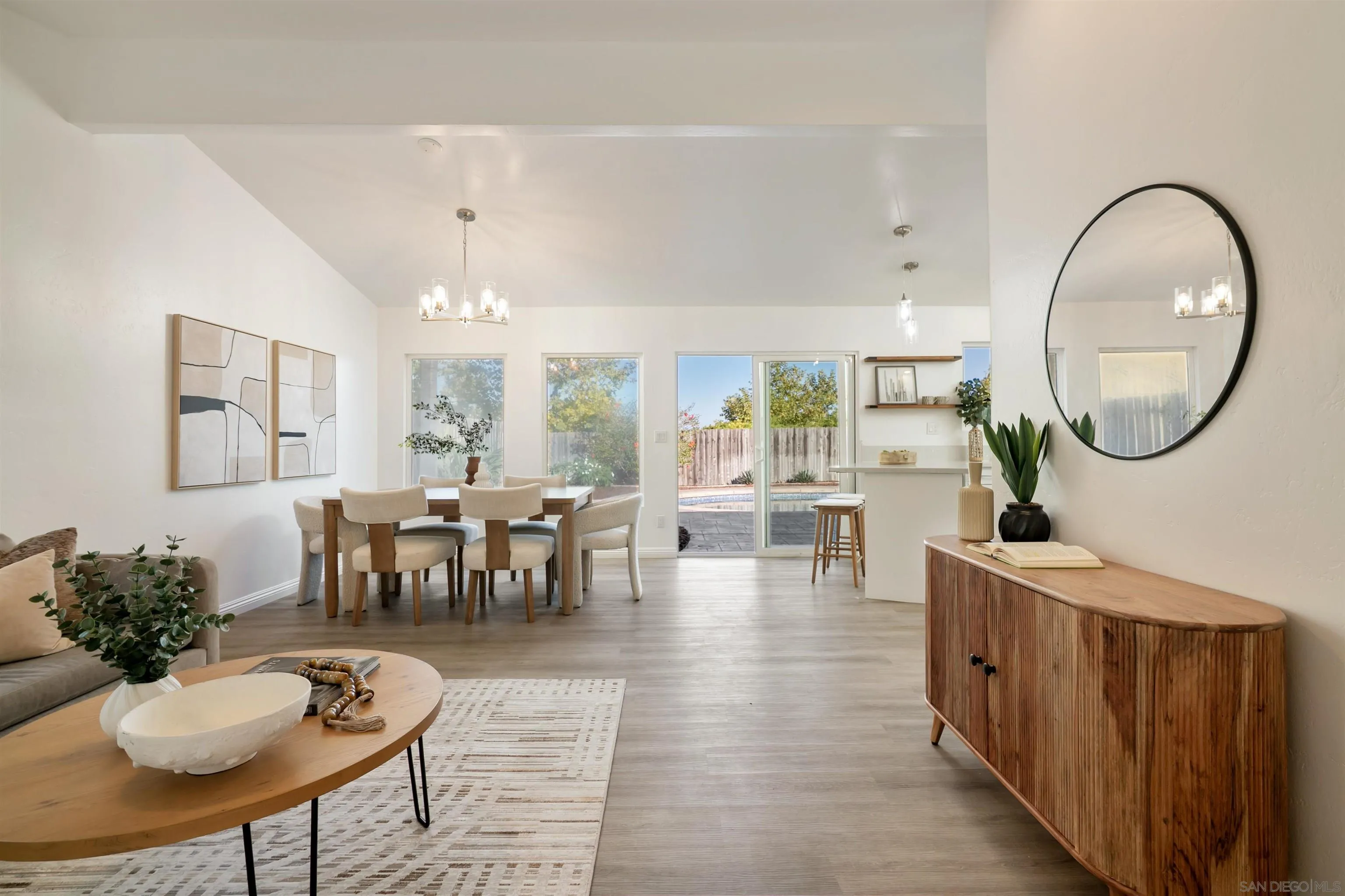 2015 Ainsley Road San Diego, CA 92123 - Photo 16 of 54 a dining room with wooden floor a chandelier a glass table and chairs