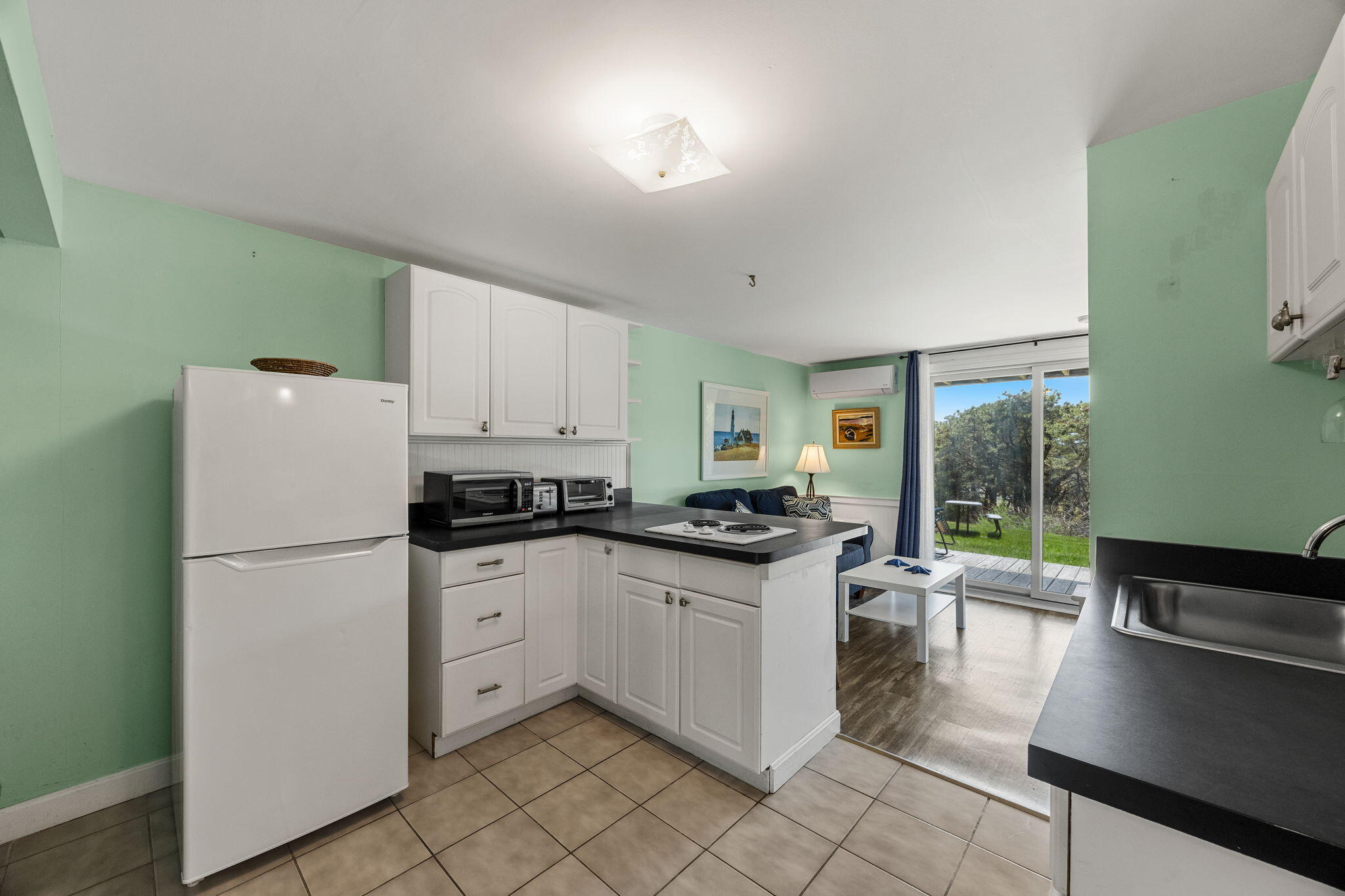 132 Shore Road, Unit 13 Truro, MA 02666 - Photo 7 of 21 a kitchen with granite countertop white cabinets and white appliances