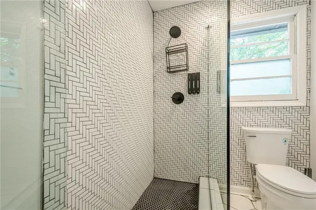 a bathroom with a toilet and a shower