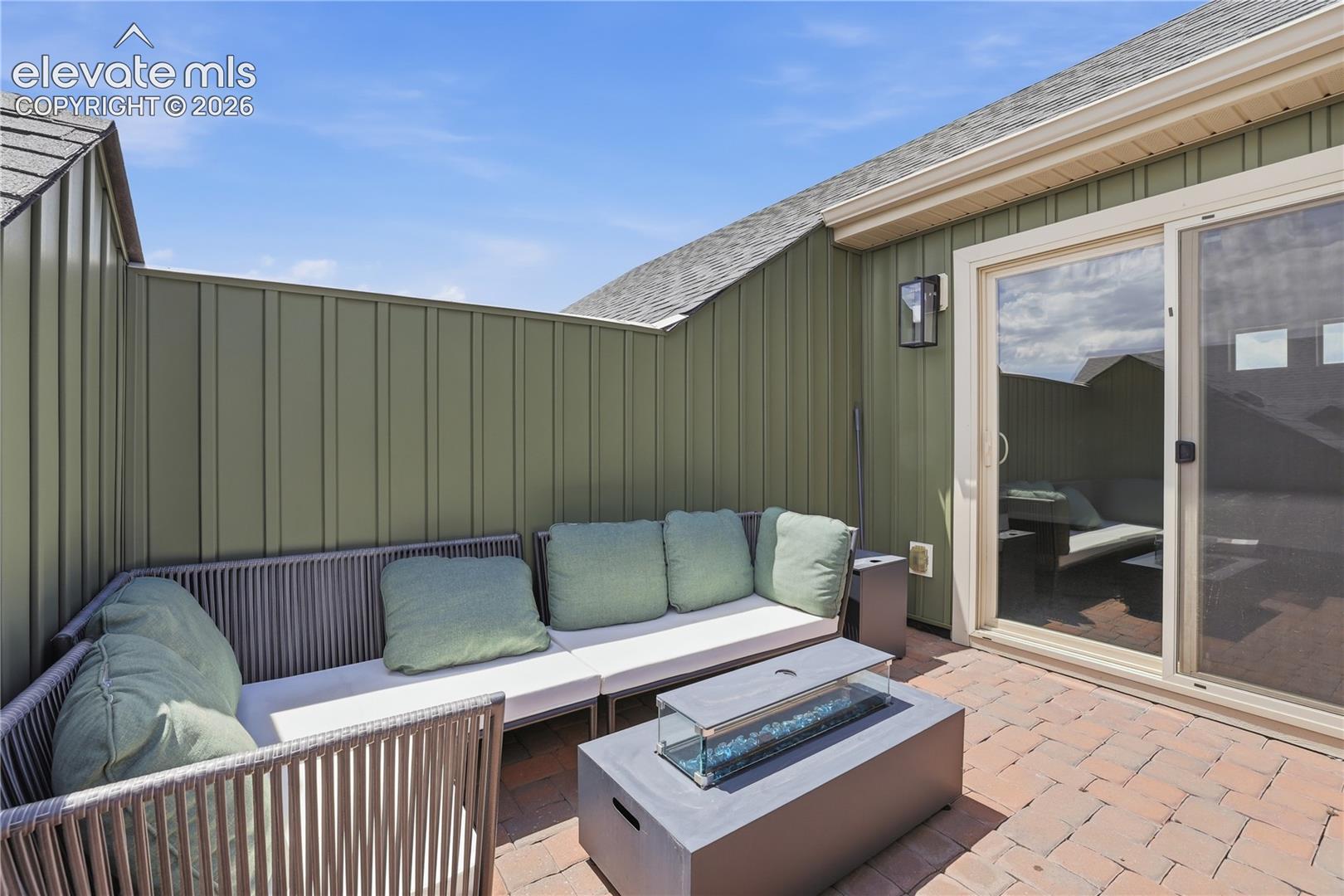 6008 Ashmore Road Colorado Springs, CO 80927 - Photo 39 of 48 Private rooftop patio featuring a built-in fire pit, privacy wall, outdoor wall sconce, and sliding glass door access