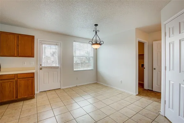 an empty room with windows and chandelier