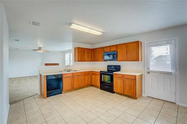 a large kitchen with stainless steel appliances granite countertop a stove sink and cabinets