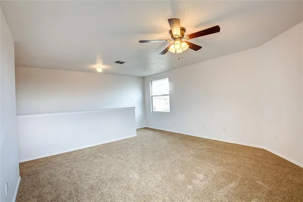 an empty room with windows and fan