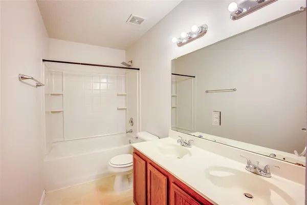 a bathroom with a toilet a sink a mirror and a shower