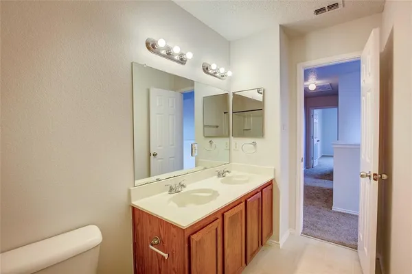 a bathroom with a sink a toilet a mirror and shower