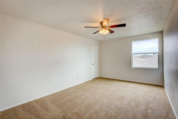 an empty room with windows and fan