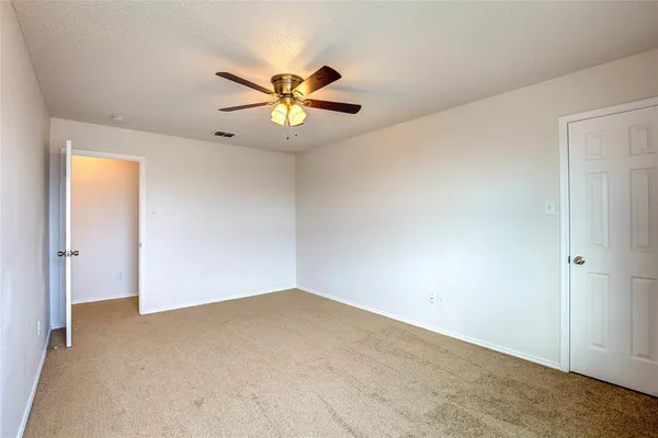 a view of a big room with wooden floor and chandelier fan